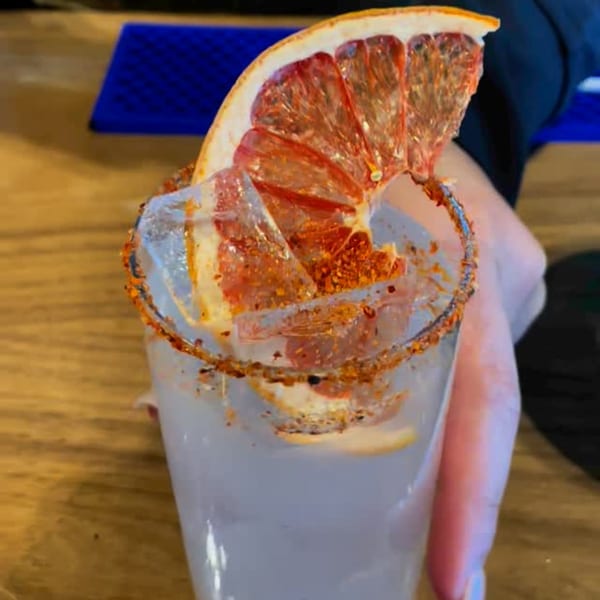 A Los Compas Margaritatown margarita with a chili-lime rim, ice, and a grapefruit slice.